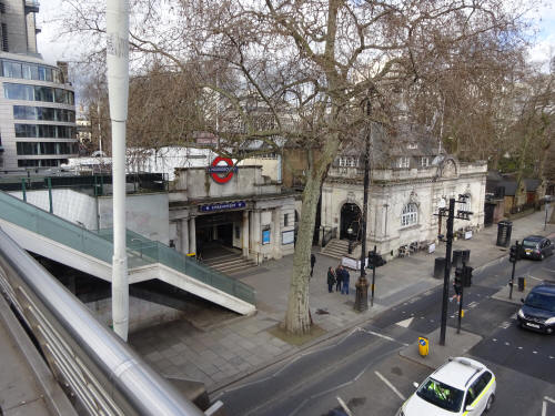 Golden cross bridge walkway - by Embankment station entrance, stairs down and Hungerford House, in March 2020